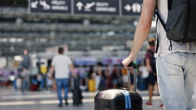 hand of man holding suitcase at airport 2026 03 18 20 40 19 utc Large