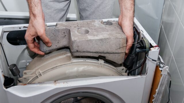 man repairing washing machine in brightly lit bath 2026 03 17 20 09 02 utc Large